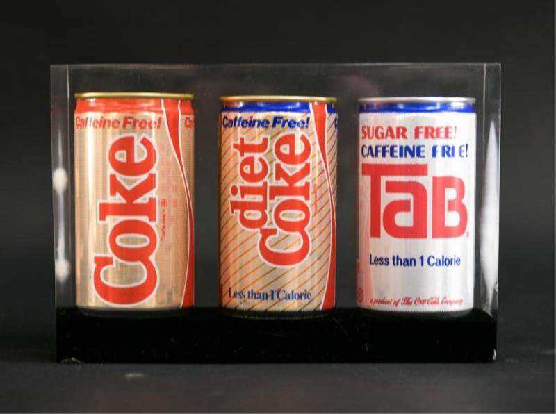 20TH C. SUSPENDED COCA COLA CANS IN LUCITE